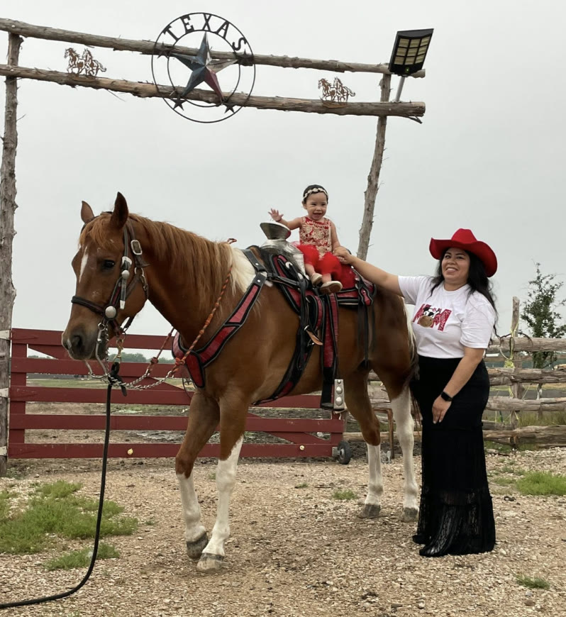 Little girl on horseback under the ranch arch