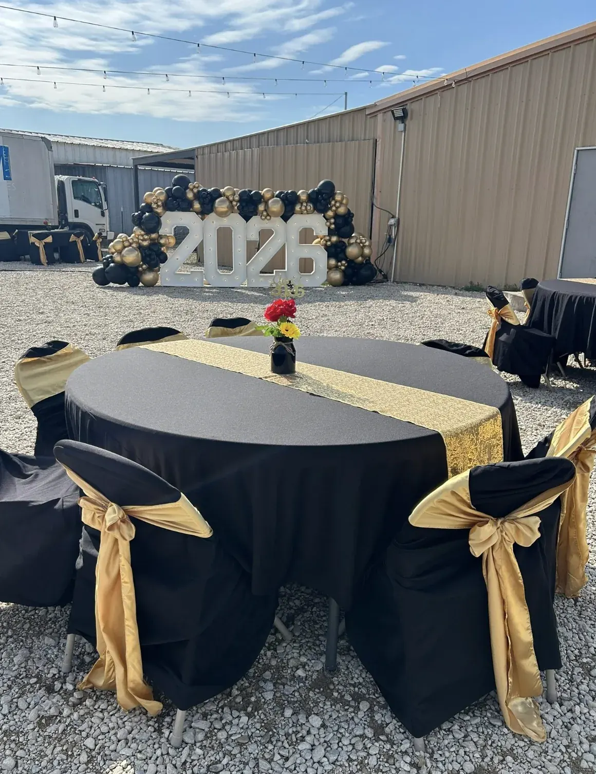 Black and gold celebration table in front of a 2026 display