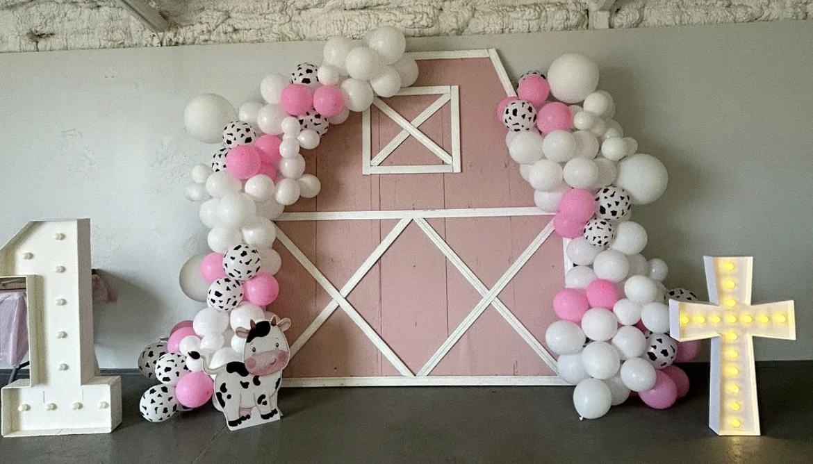 Pink barn backdrop framed by a balloon arch